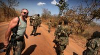 PIC BY KEVIN EVANS / CATERS NEWS - (PICTURED Machine Gun Preacher Sam Childers, South Sudan) - Meet the real-life Machine Gun Preacher, the incredible gun-totting reformed drug and alcohol abusing biker who went on to rescue orphans from blood-thirsty rebels who skin people ALIVE. Sam Childers might look like the archetypal handlebar-moustached Hells Angels type and thats because he was until he made a decision that changed his life. That life - which saw him leave his native USA and travel thousands of miles to East Africa - is now the subject Hollywood blockbuster Machine Gun Preacher released in the UK tomorrow (WEDS). Hunky heart-throb Gerard Butler plays Sam in the film which documents his real-life battle to rescue hundreds of children kidnapped in Africa. SEE CATERS COPY