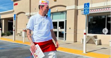 Man in In-N-Out Burger uniform outside restaurant.