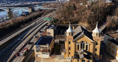 Inside a historic church painted with murals that reflect searing social commentary