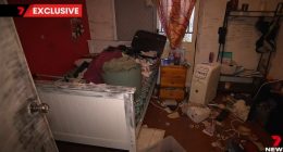 Messy bedroom with belongings strewn across the floor and bed.