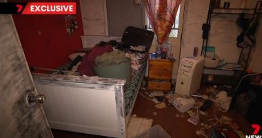 Messy bedroom with belongings strewn across the floor and bed.