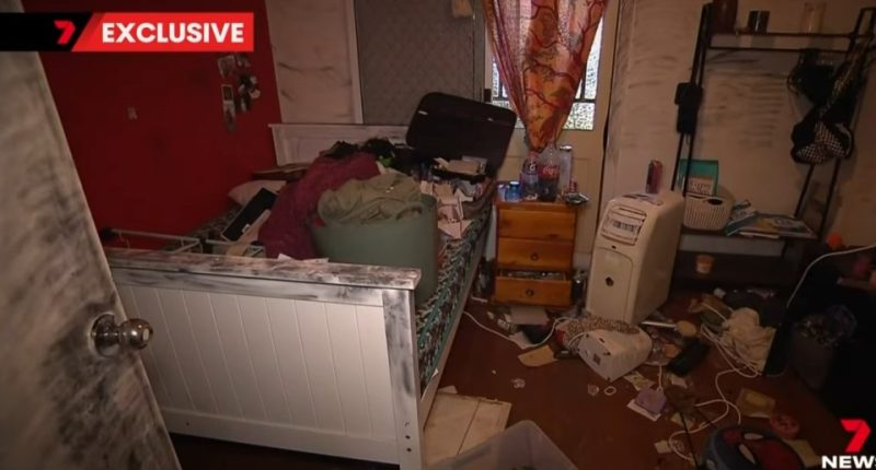 Messy bedroom with belongings strewn across the floor and bed.