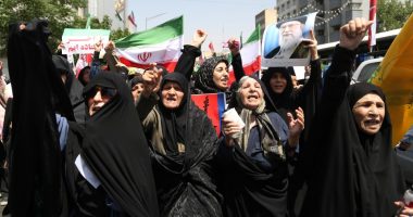 Thousands of Iranians waving flags and protesting.