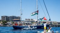 CATANIA, ITALY - JUNE 01: Just before the departure of the Madleen, the Freedom Flotilla vessel, a young man raises the Palestinian flag from a pedal boat as other boats fly the same flag off the port of San Giovanni Li Cuti on June 01, 2025 in Catania, Italy. Swedish activist Greta Thunberg is among those who will attempt to sail to Gaza on a boat organized by the Freedom Flotilla Coalition (FFC), in a bid to break Israel's blockade of the Palestinian territory. Freedom Flotilla had to abort a previous journey in early May after it said its boat came under attack by drones in international waters near Malta. (Photo by Fabrizio Villa/Getty Images)