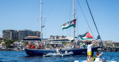 CATANIA, ITALY - JUNE 01: Just before the departure of the Madleen, the Freedom Flotilla vessel, a young man raises the Palestinian flag from a pedal boat as other boats fly the same flag off the port of San Giovanni Li Cuti on June 01, 2025 in Catania, Italy. Swedish activist Greta Thunberg is among those who will attempt to sail to Gaza on a boat organized by the Freedom Flotilla Coalition (FFC), in a bid to break Israel's blockade of the Palestinian territory. Freedom Flotilla had to abort a previous journey in early May after it said its boat came under attack by drones in international waters near Malta. (Photo by Fabrizio Villa/Getty Images)