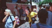 A woman uses a fan to cool herself near Monastiraki Square in Athens, Greece