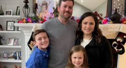Family portrait in front of a fireplace.