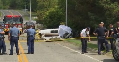 Small plane crash scene on a street near an airport.