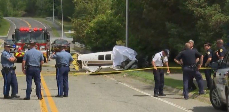 Small plane crash scene on a street near an airport.