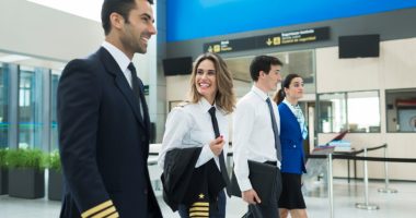 Plane crew walking through an airport terminal.