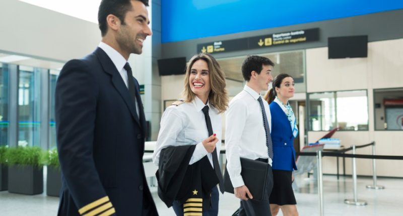 Plane crew walking through an airport terminal.