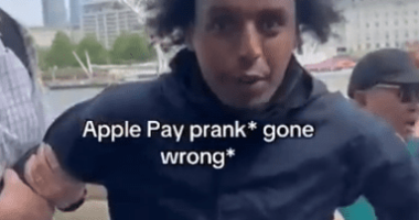 Man being detained, Apple Pay prank gone wrong, London Eye in background.