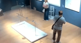 High-angle view of two people in an art gallery near a damaged art installation.