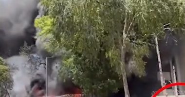 Large fire with people watching from a distance.