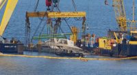 Crane ships lifting a sunken yacht.