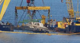 Crane ships lifting a sunken yacht.