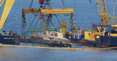 Crane ships lifting a sunken yacht.