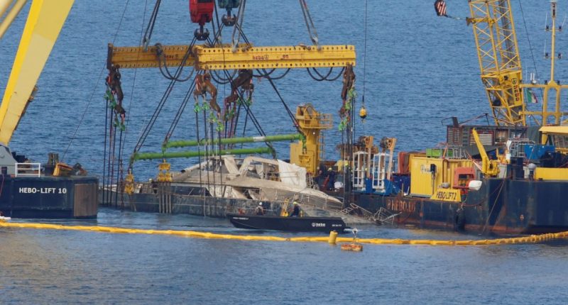 Crane ships lifting a sunken yacht.