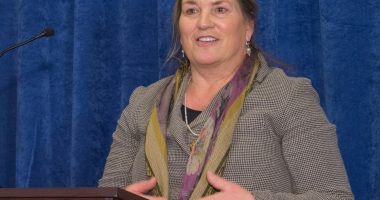 Photo of Joanna Miller speaking at a podium.