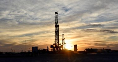 Drilling rigs operate at sunset in Midland, Texas