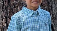 Photo of a young boy in a blue and green checkered shirt.