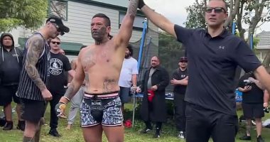 Pictured: UFC star Dan Hooker (left, in baseball cap and singlet) watches as gang member Jon Paul 'Fightdog' Te Rito is awarded a win in his backyard fight fest in Auckland