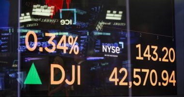 A monitor displays stock market information on the floor of the New York Stock Exchange