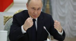 Vladimir Putin gesturing during a meeting with Russian business leaders.