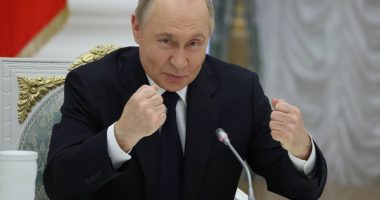 Vladimir Putin gesturing during a meeting with Russian business leaders.