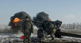 Russian troops firing howitzers during military exercises.