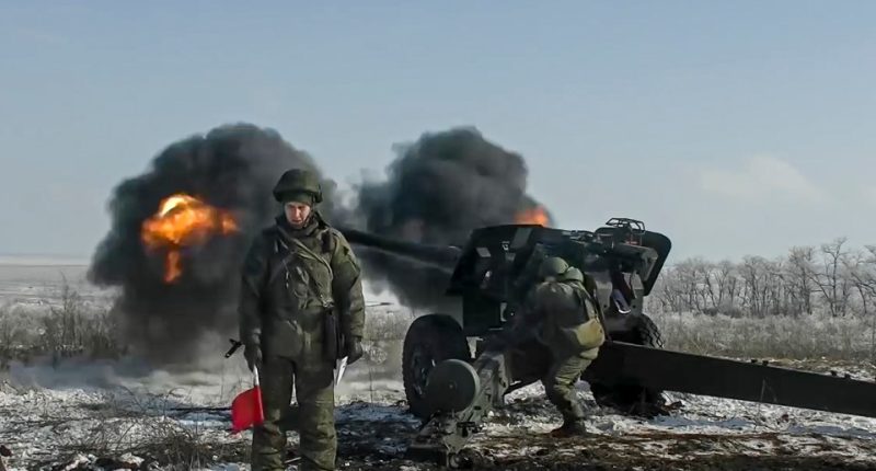 Russian troops firing howitzers during military exercises.