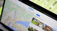 Laptop displaying Zillow real estate listings.