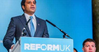 A man in a suit speaks at a Reform UK press conference.