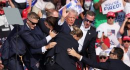 U.S. President Donald Trump gestures with a bloodied face while he is assisted by U.S. Secret Service personnel after he was shot