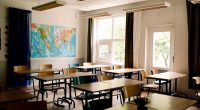 Empty classroom with desks and chairs arranged in rows.