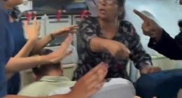 A passenger arguing with flight attendants on an airplane.