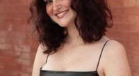 Portrait of a smiling teenage girl wearing a black dress.
