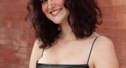 Portrait of a smiling teenage girl wearing a black dress.
