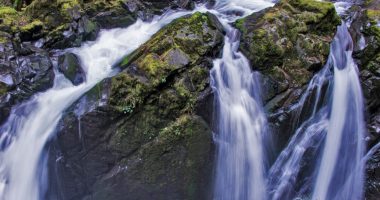 Water cascading over moss-covered rocks.