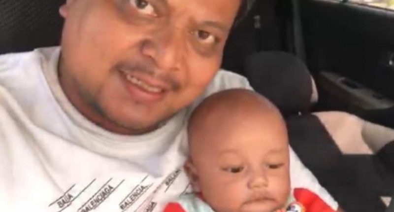 Photo of a father and his baby son in a car.