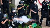 LAPD officers firing less-lethal projectiles at protesters.