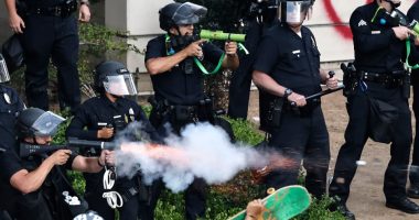 LAPD officers firing less-lethal projectiles at protesters.