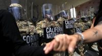 Protesters clasp hands in front of a line of California National Guard, Monday, June 9, 2025, at a Federal Building in downtown Los Angeles. (AP Photo Jae Hong)