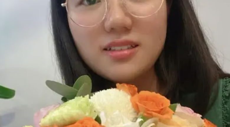 Yunqing Jian holding a bouquet of flowers.
