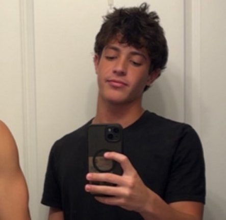 A young man taking a selfie in a bathroom mirror.