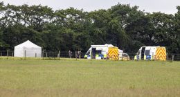 Police and forensic vehicles at a skydiving accident scene.