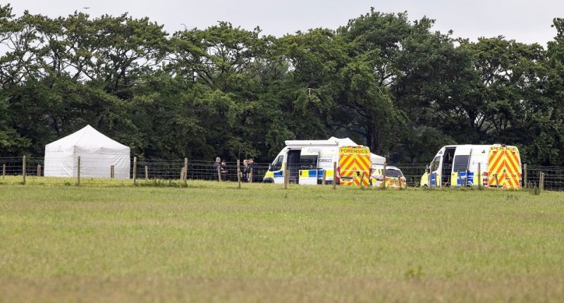 Police and forensic vehicles at a skydiving accident scene.