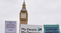 Banners are held by pro-assisted dying campaigners as they gather outside Parliament in London, May 15, 2025