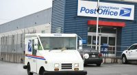 USPS mail truck leaving a post office.