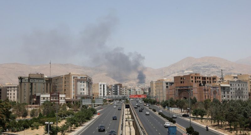 Smoke rises over a Tehran highway.